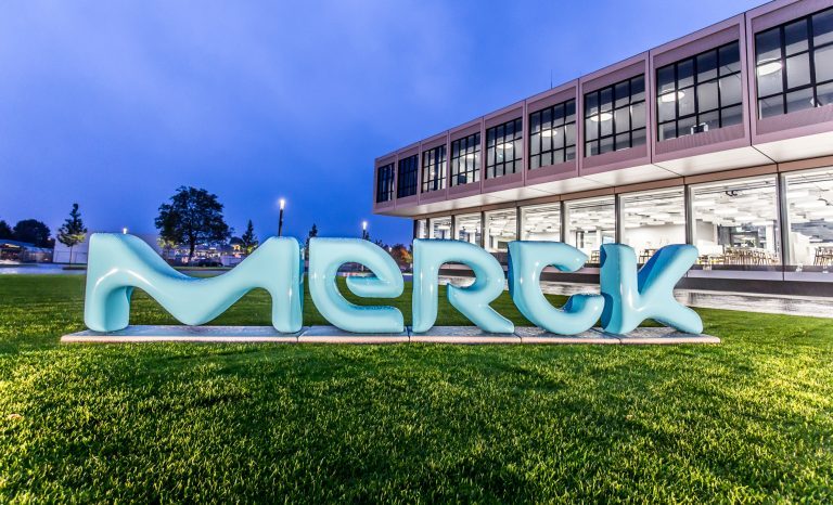 Merck Logo auf einer Wiese vor einem Gebäude