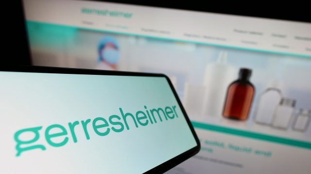 Mobiltelefon mit dem Logo des deutschen Verpackungsunternehmens Gerresheimer AG auf dem Bildschirm vor einer Unternehmenswebsite mit Fokus auf die rechte Mitte des Telefondisplay