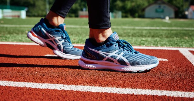 Männlicher Sprinter, welcher die ASICS Gel Nimbus auf der Laufbahn trägt