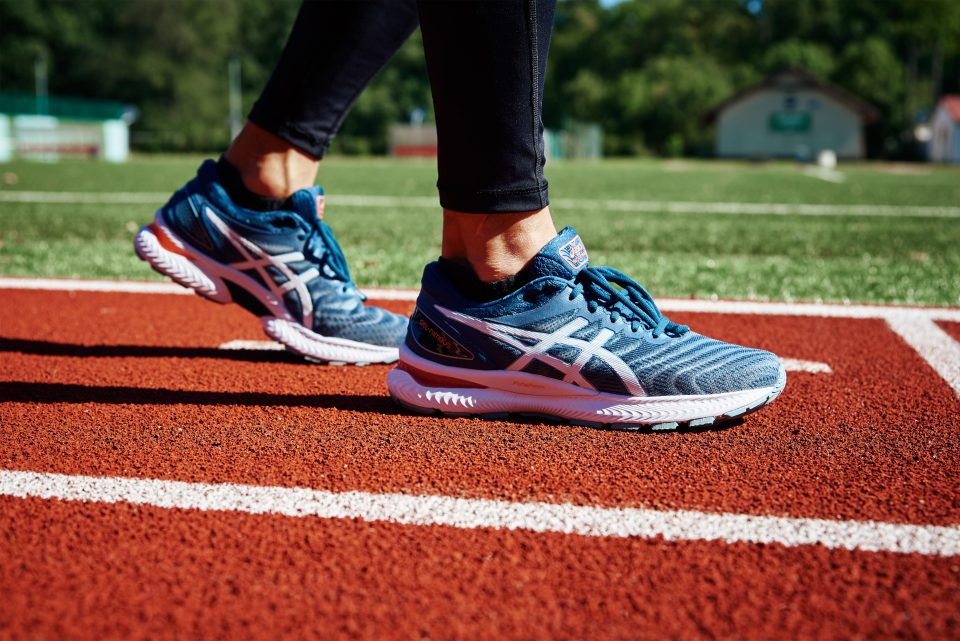 Männlicher Sprinter, welcher die ASICS Gel Nimbus auf der Laufbahn trägt