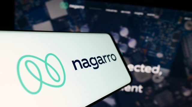Ein Mobiltelefon mit Logo des Informationstechnologieunternehmens Nagarro SE auf dem Bildschirm vor einer Unternehmenswebsite mit Fokus auf die Mitte des Telefondisplays