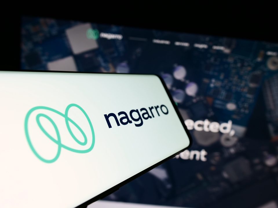 Ein Mobiltelefon mit Logo des Informationstechnologieunternehmens Nagarro SE auf dem Bildschirm vor einer Unternehmenswebsite mit Fokus auf die Mitte des Telefondisplays