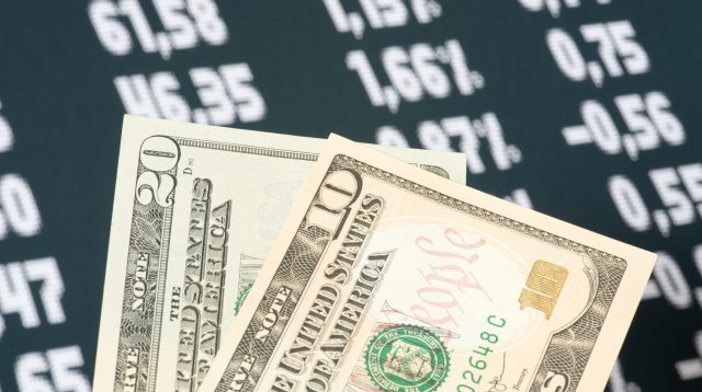 Dollar-Scheine und Kurse im Hintergrund