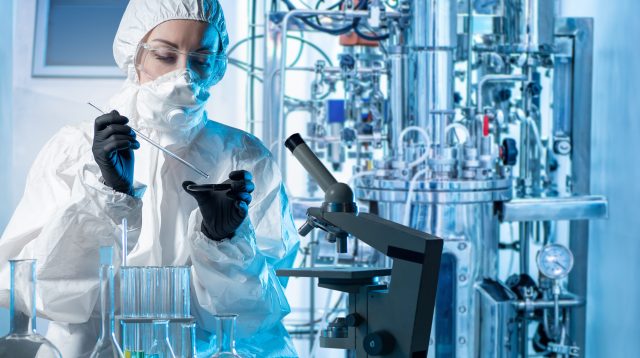 Laboratory assistant with microscope bio tech.