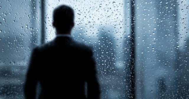 CEO vor einer verregneten Fensterscheibe