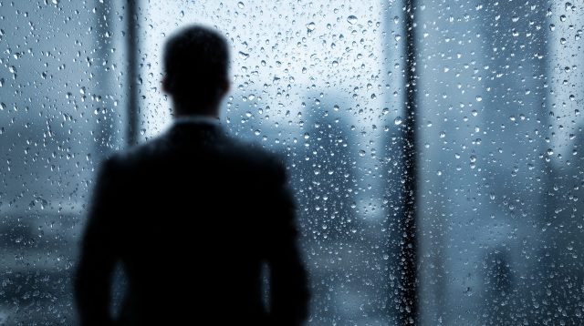 CEO vor einer verregneten Fensterscheibe
