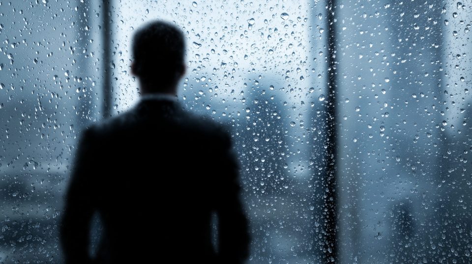 CEO vor einer verregneten Fensterscheibe