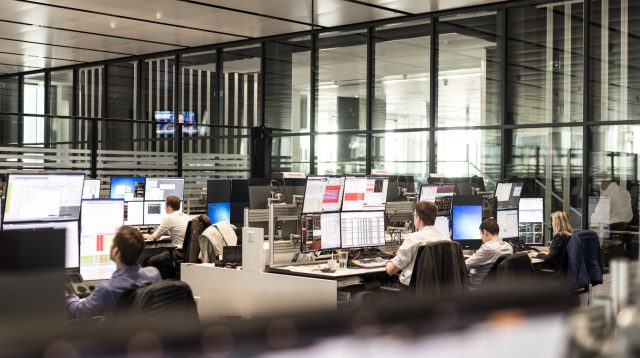 Der Handelssaal der Deutschen Bank. Zahlreiche Menschen sitzen an Computern mit vielen Bildschirmen.