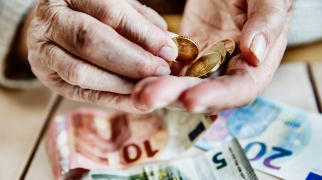Hand einer Seniorin mit Bargeld